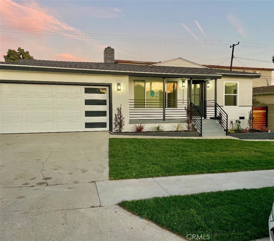 view of front of home featuring a garage and a lawn