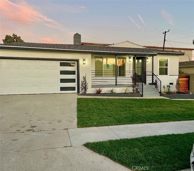 view of front of home featuring a garage and a lawn