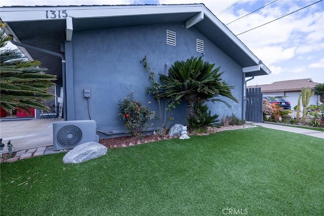 view of home's exterior with ac unit and a yard