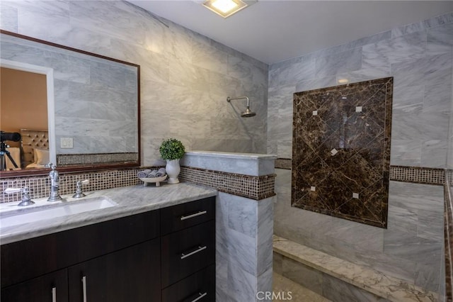 bathroom with tile walls, vanity, and a shower