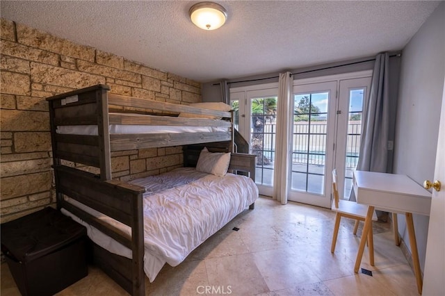 bedroom with access to exterior and a textured ceiling