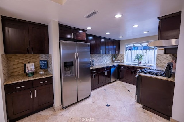 kitchen with light stone counters, backsplash, stainless steel appliances, and sink