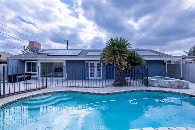 view of swimming pool featuring an in ground hot tub, a patio area, and french doors