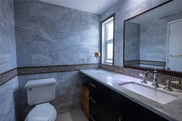 bathroom with vanity, tile walls, decorative backsplash, and toilet