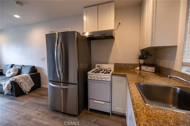 kitchen with stainless steel refrigerator, white range with gas cooktop, sink, and white cabinets