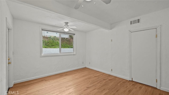 unfurnished room with beamed ceiling, ceiling fan, and light hardwood / wood-style flooring