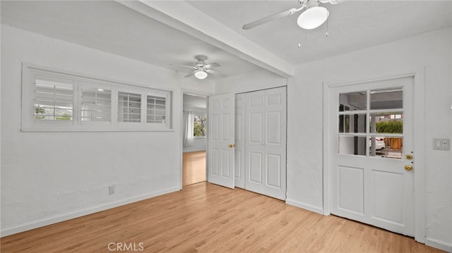 interior space with beam ceiling, ceiling fan, and light wood-type flooring