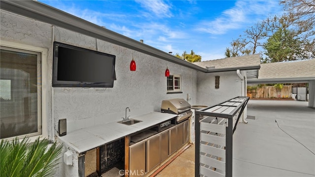 view of patio with an outdoor kitchen, a grill, and sink