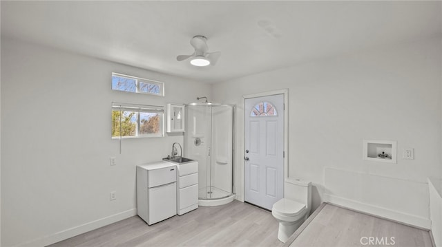 bathroom featuring wood-type flooring, sink, an enclosed shower, ceiling fan, and toilet