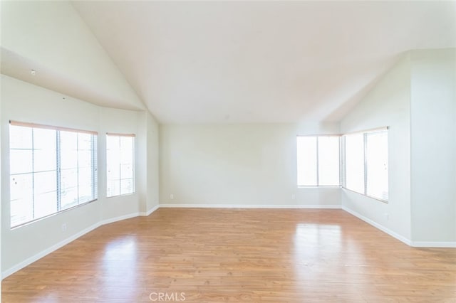 empty room with lofted ceiling and light hardwood / wood-style floors