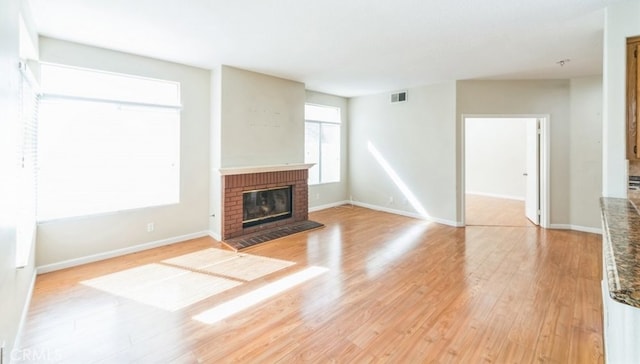 unfurnished living room with light wood-type flooring and a fireplace