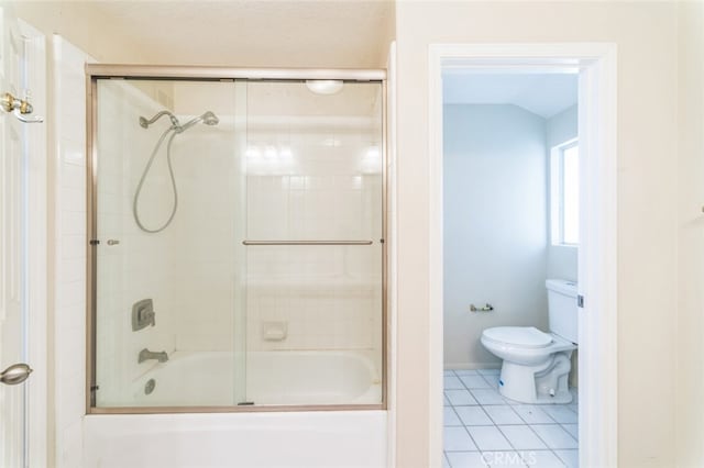 bathroom with tile patterned flooring, shower / bath combination with glass door, and toilet