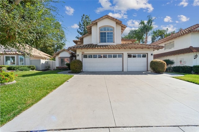 mediterranean / spanish house with a garage and a front yard