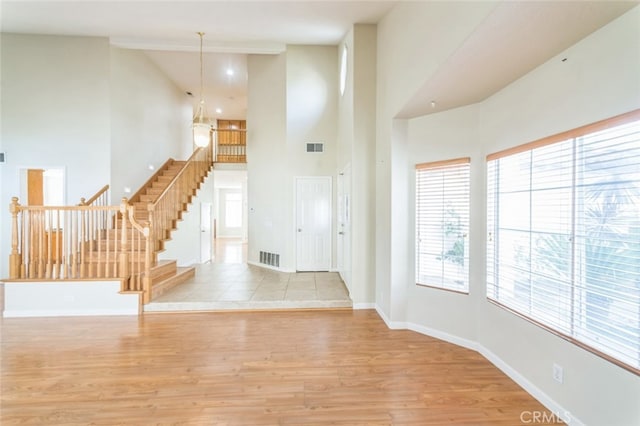 entrance foyer featuring a towering ceiling and light hardwood / wood-style floors