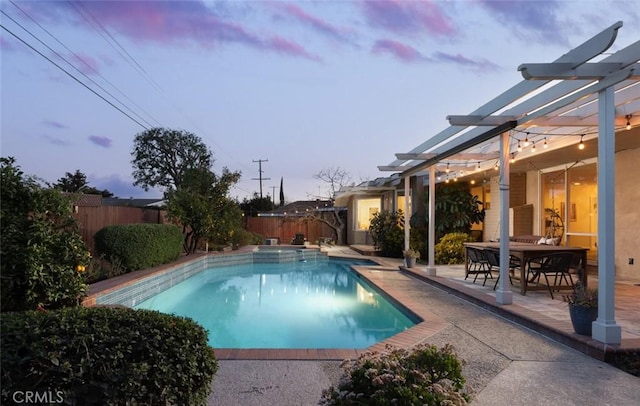 pool at dusk featuring a pergola and a patio area