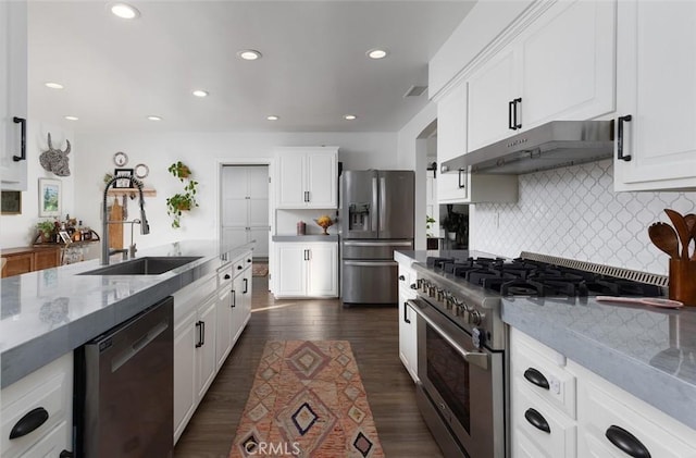 kitchen with sink, stainless steel appliances, light stone countertops, white cabinets, and decorative backsplash