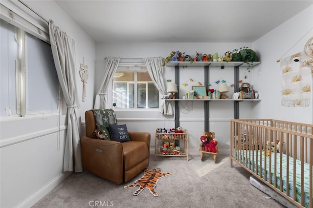 bedroom with a nursery area and carpet floors