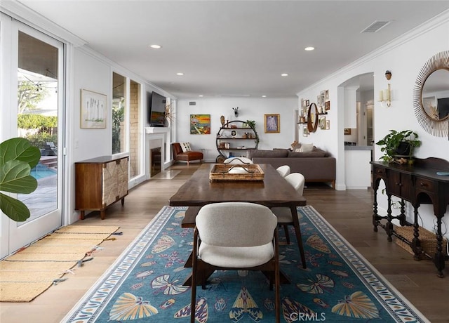 dining space featuring ornamental molding and dark hardwood / wood-style flooring