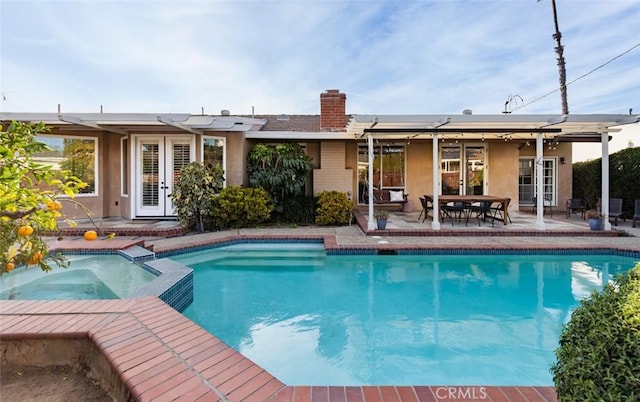 view of swimming pool with a patio and an in ground hot tub