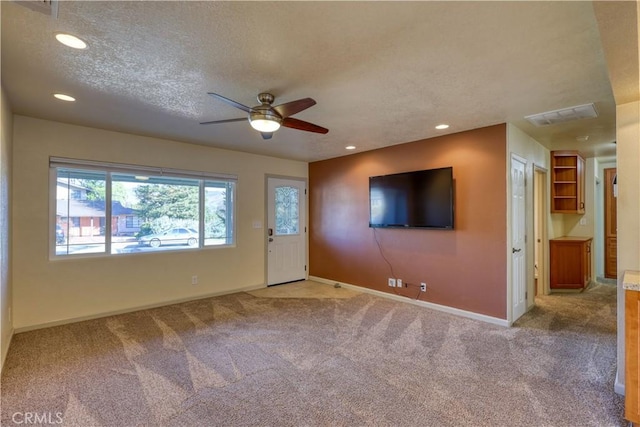 unfurnished living room with light carpet, a textured ceiling, and ceiling fan