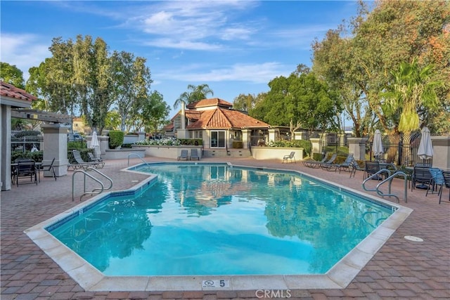 pool with a gazebo, a patio, and fence