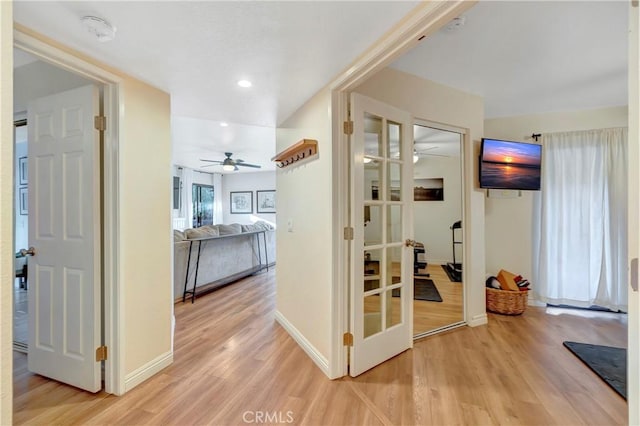 corridor featuring recessed lighting, light wood-type flooring, baseboards, and french doors