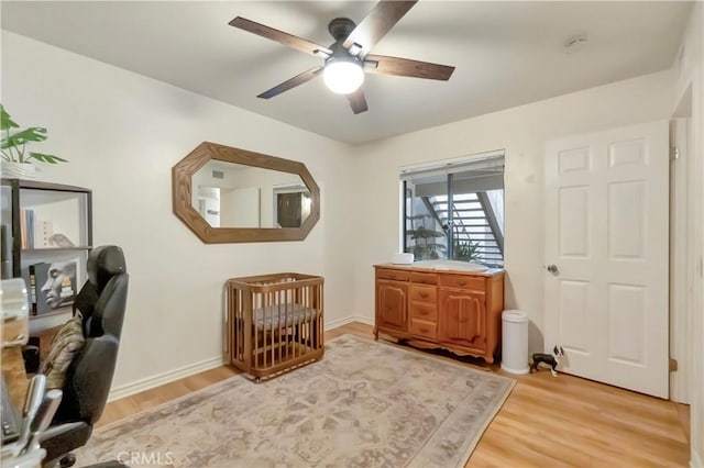 office featuring light wood-style flooring, a ceiling fan, and baseboards