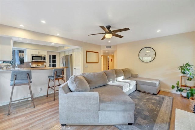 living area with recessed lighting, visible vents, and light wood finished floors