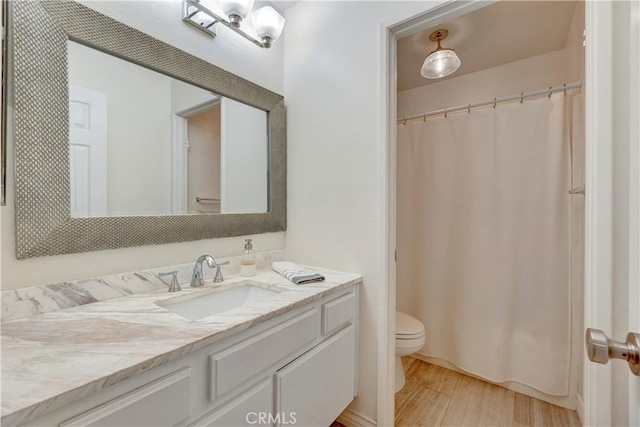 full bath featuring vanity, a shower with shower curtain, toilet, and wood finished floors