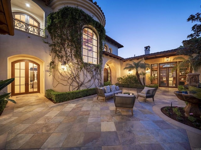 patio terrace at dusk with french doors and an outdoor hangout area