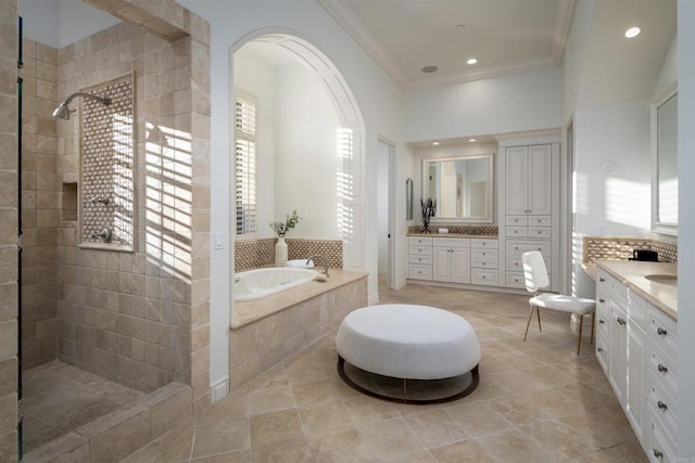 bathroom with vanity, ornamental molding, and separate shower and tub