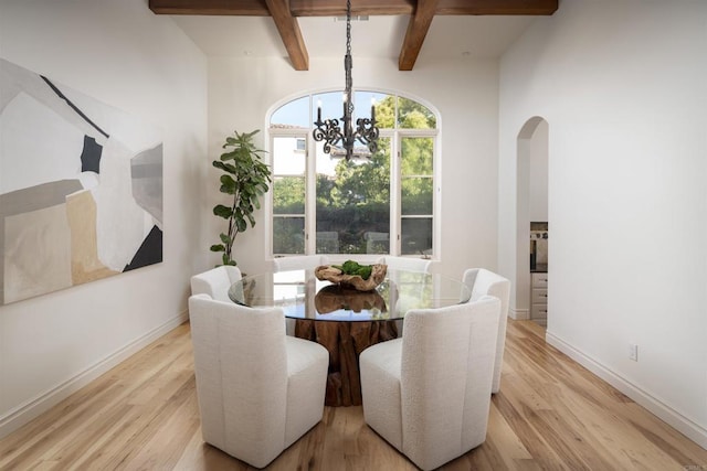 dining room with coffered ceiling, an inviting chandelier, beam ceiling, and light hardwood / wood-style floors