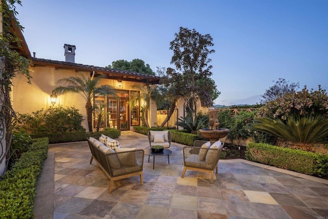 patio terrace at dusk featuring an outdoor living space