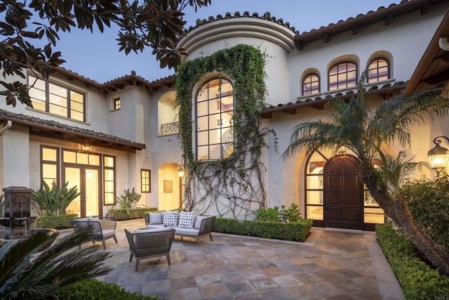 back of property featuring stucco siding, an outdoor hangout area, and a patio area