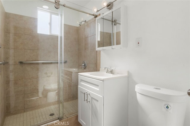 bathroom with vanity, toilet, and a shower with shower door