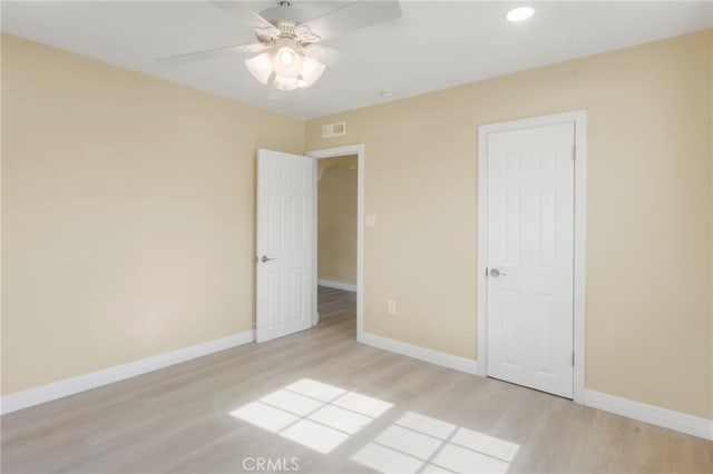 unfurnished bedroom with ceiling fan, light hardwood / wood-style floors, and a closet