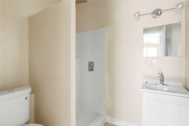 bathroom featuring vanity, a shower, and toilet