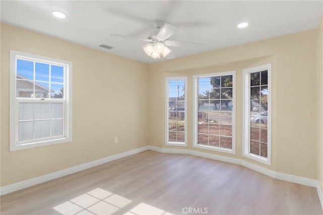 spare room with ceiling fan, light hardwood / wood-style flooring, and a healthy amount of sunlight