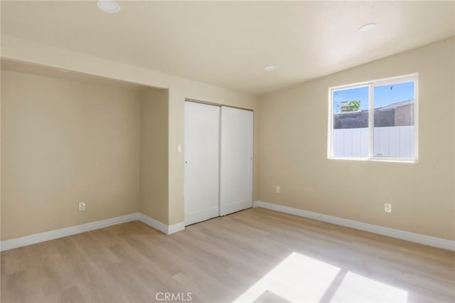 unfurnished bedroom featuring light hardwood / wood-style floors and a closet