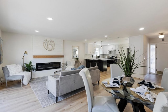 interior space with a healthy amount of sunlight, a large fireplace, and light wood-type flooring