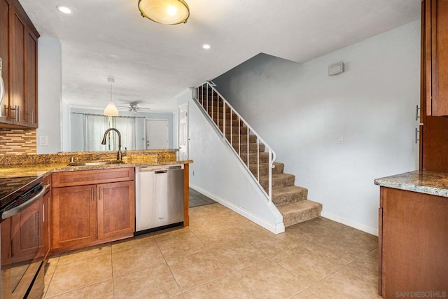 kitchen featuring sink, backsplash, hanging light fixtures, light stone counters, and stainless steel appliances