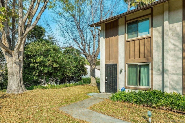 view of exterior entry featuring a yard