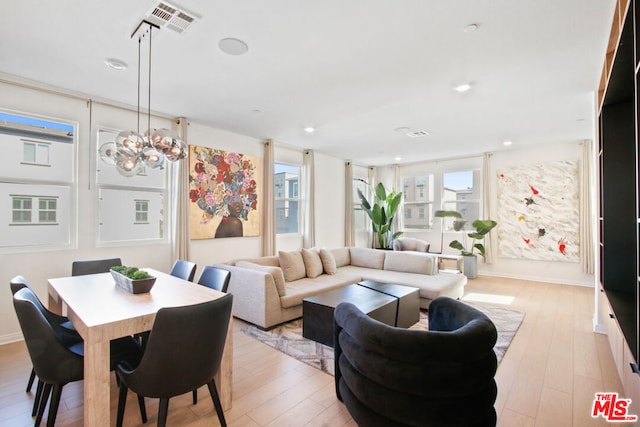 interior space featuring a notable chandelier, a wealth of natural light, and light hardwood / wood-style flooring