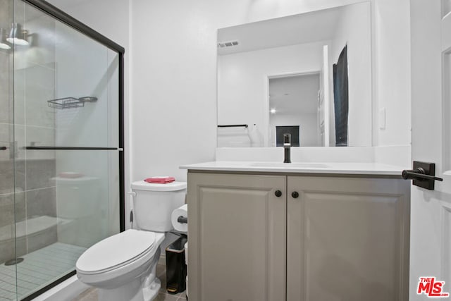 bathroom with vanity, walk in shower, and toilet