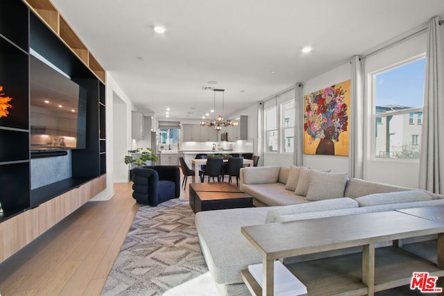 living room featuring an inviting chandelier and light wood-type flooring