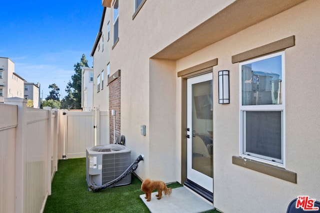 property entrance with a lawn and central air condition unit