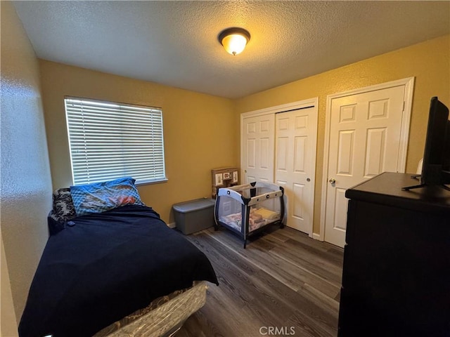 bedroom with dark hardwood / wood-style floors and a textured ceiling