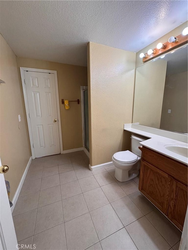 bathroom featuring tile patterned flooring, vanity, toilet, a shower with door, and a textured ceiling