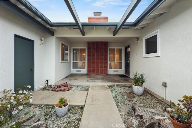 view of exterior entry featuring a patio area