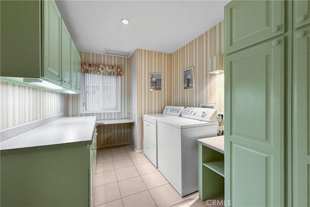 laundry area featuring light tile patterned floors, washer and clothes dryer, and cabinets